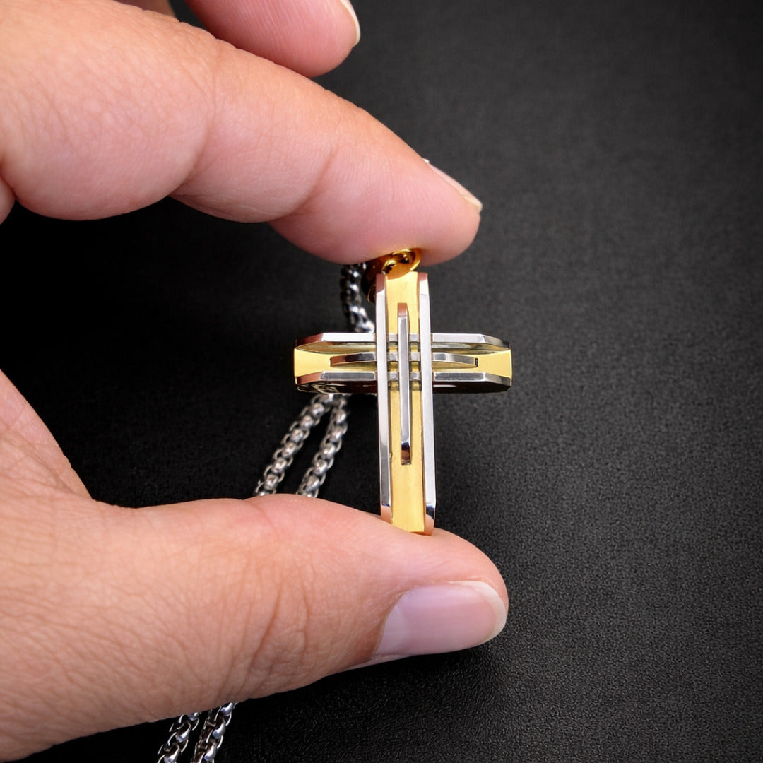 Close up of silver and gold cross pendant stainless steel detailed engraving modern necklace