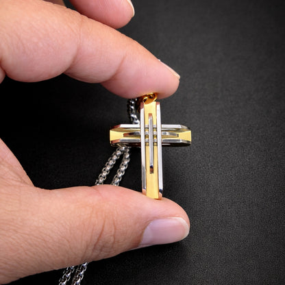 Close up of silver and gold cross pendant stainless steel detailed engraving modern necklace